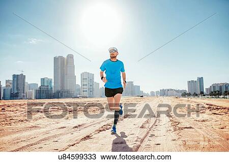 "Full length front view of mid adult man running on sand by sky scrapers, Dubai, United Arab Emirates" View Large Photo Image Stock Image - "Full length front view of mid adult man running on sand by sky scrapers, Dubai, United Arab Emirates". Fotosearch
