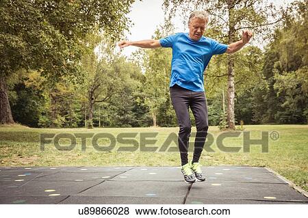 Full length front view of senior man in park jumping in mid air View Large Photo Image Stock Photo - Full length front view of senior man in park jumping in mid air. Fotosearch