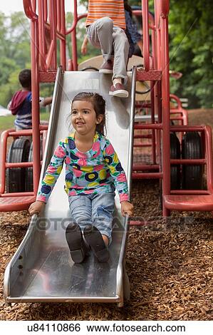Girl and friends sliding on playground slide View Large Photo Image Stock Photograph - Girl and friends sliding on playground slide. Fotosearch