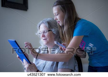 Stock Photo - Girl and grandmother using tablet. Fotosearch