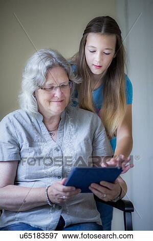 Stock Photo - Girl and grandmother using tablet. Fotosearch
