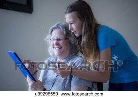 Girl and grandmother using tablet View Large Photo Image Stock Photo - Girl and grandmother using tablet. Fotosearch