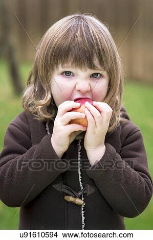 Girl eating an apple View Large Photo Image Picture - Girl eating an apple. Fotosearch
