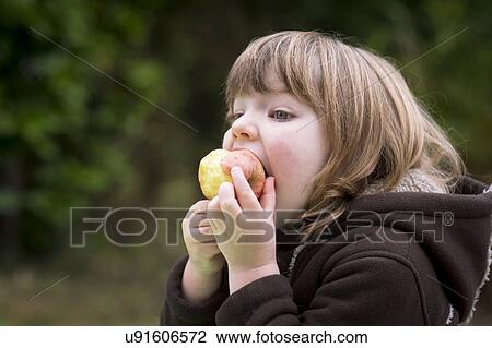 Stock Image - Girl eating an apple. Fotosearch