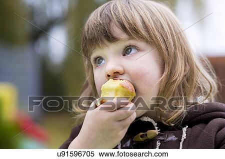Stock Photography - Girl eating an apple. Fotosearch