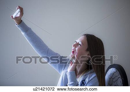Girl taking selfie on smartphone View Large Photo Image Stock Image - Girl taking selfie on smartphone. Fotosearch