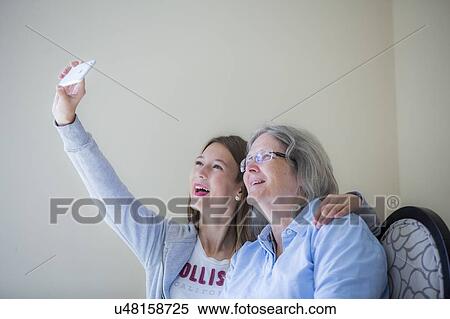 Stock Photography - Girl taking selfie on smartphone. Fotosearch