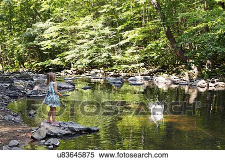 Stock Photography - Girl throwing stone into river. Fotosearch