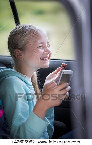 Girl using smartphone in car View Large Photo Image Stock Image - Girl using smartphone in car. Fotosearch