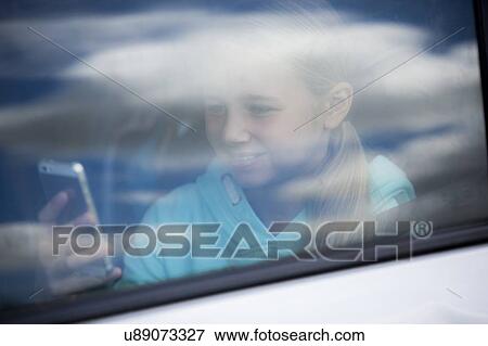 Girl using smartphone in car View Large Photo Image Stock Photo - Girl using smartphone in car. Fotosearch