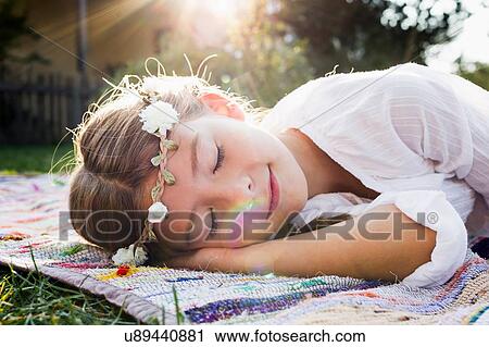 Stock Image - Girl with flowers round head sleeping. Fotosearch