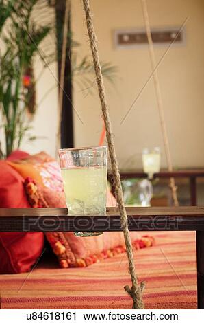 Stock Image - Glass of lemonade on swing seat. Fotosearch