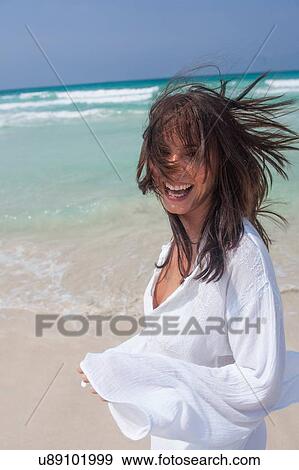 Stock Photo - Happy young woman running on beach, Majorca, Spain. Fotosearch