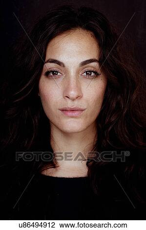 Stock Image - Head and shoulder portrait of beautiful young woman with long brown hair. Fotosearch