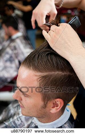High angle view of young man in barbershop having haircut View Large Photo Image Stock Photo - High angle view of young man in barbershop having haircut. Fotosearch