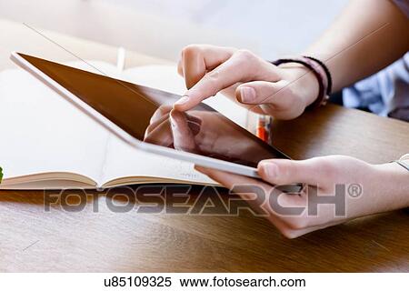 High angle view of young womans hands using digital tablet View Large Photo Image Stock Photography - High angle view of young womans hands using digital tablet. Fotosearch