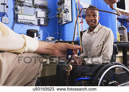 Stock Image - Instructor with student in wheelchair. Fotosearch