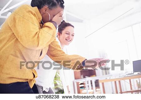 Stock Photo - Low angle view of women in team building task, holding hands covering eyes. Fotosearch
