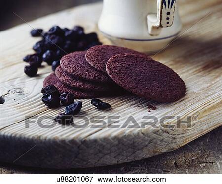 Stock Photo - Luxury blackcurrant thins on vintage wooden cutting board. Fotosearch