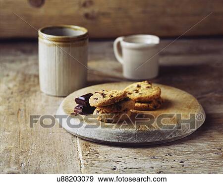 Stock Photo - Luxury dark chocolate cookies on vintage wooden cutting board. Fotosearch
