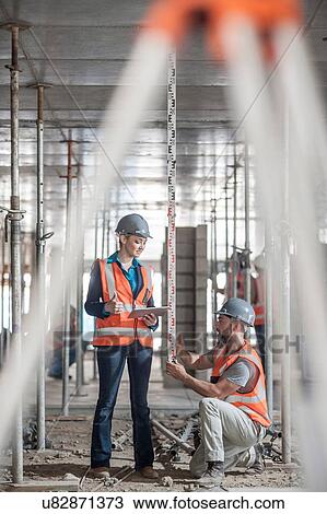 Male and female builders measuring construction with ruler View Large Photo Image Stock Image - Male and female builders measuring construction with ruler. Fotosearch