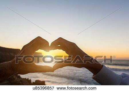 Male and female hands making sunset heart shape, Los Molinos, Fuerteventura, Spain View Large Photo Image Stock Photo - Male and female hands making sunset heart shape, Los Molinos, Fuerteventura, Spain. Fotosearch