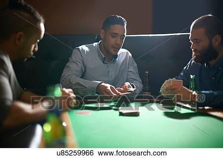 Male friends dealing playing card for game at pub card table View Large Photo Image Stock Photograph - Male friends dealing playing card for game at pub card table. Fotosearch