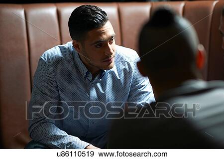 Stock Photo - Male friends having discussion in traditional UK pub. Fotosearch