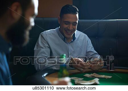 Male friends playing card game for cash at pub card table View Large Photo Image Stock Image - Male friends playing card game for cash at pub card table. Fotosearch