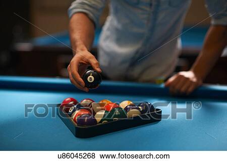 Man arranging balls into triangle on pool table View Large Photo Image Stock Photo - Man arranging balls into triangle on pool table. Fotosearch