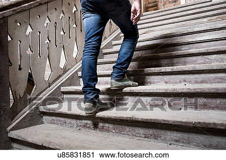 Stock Image - Man going up staircase. Fotosearch