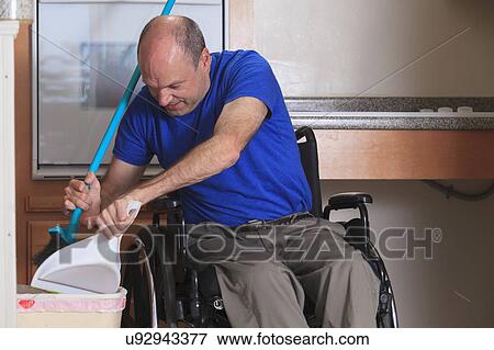 Stock Photo - Man in wheelchair cleaning his house. Fotosearch