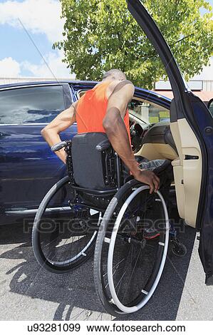 Man in wheelchair entering a car View Large Photo Image Stock Photo - Man in wheelchair entering a car. Fotosearch