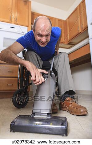 Man in wheelchair vacuuming his house View Large Photo Image Stock Image - Man in wheelchair vacuuming his house. Fotosearch