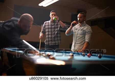Man playing pool, friends drinking beer in background View Large Photo Image Stock Photography - Man playing pool, friends drinking beer in background. Fotosearch