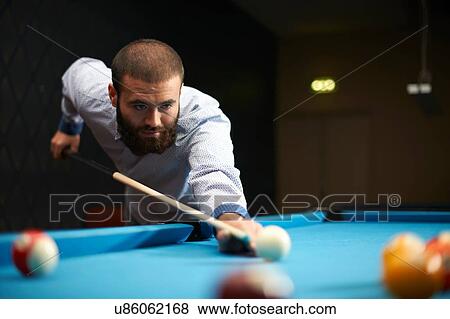 Stock Photo - Man playing pool in club. Fotosearch