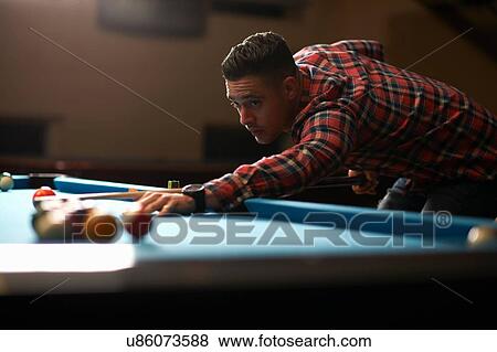 Stock Photo - Man playing pool in club. Fotosearch