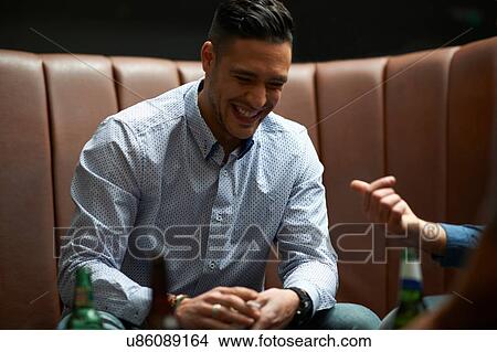 Picture - Man shuffling playing cards in game at traditional UK pub. Fotosearch