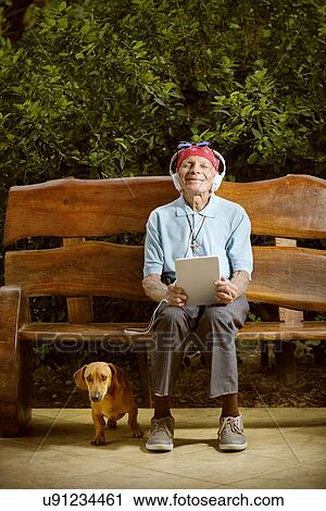 Stock Image - Man sitting on bench with dog. Fotosearch