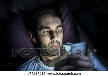 Stock Photography - Man using smartphone in dark. Fotosearch