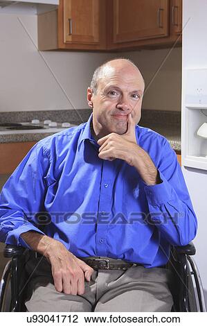 Stock Image - Man with deformed hands in his wheelchair. Fotosearch