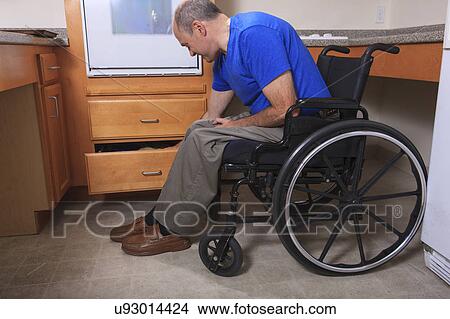 Picture - Man with deformed hands in the kitchen. Fotosearch
