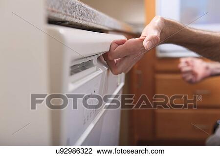 Stock Image - Man with deformed hands in the kitchen. Fotosearch