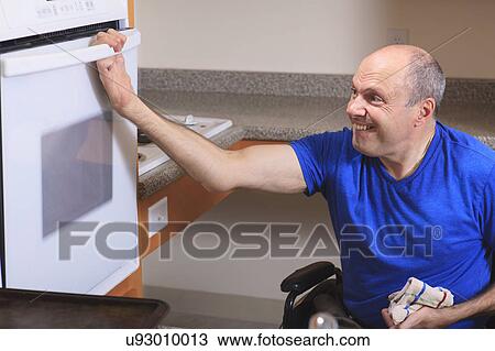 Stock Image - Man with deformed hands in the kitchen. Fotosearch