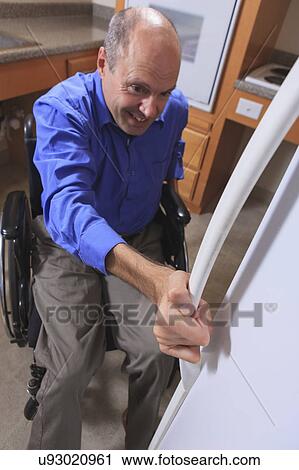 Stock Image - Man with deformed hands in the kitchen. Fotosearch