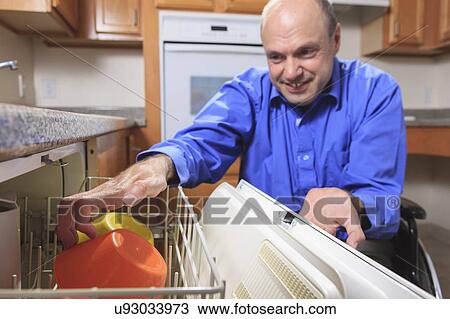 Stock Image - Man with deformed hands in the kitchen. Fotosearch
