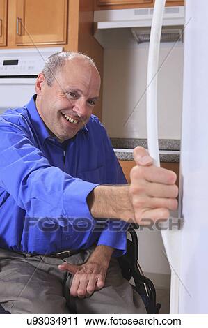 Stock Image - Man with deformed hands in the kitchen. Fotosearch