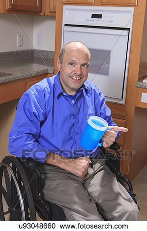 Stock Image - Man with deformed hands in the kitchen. Fotosearch