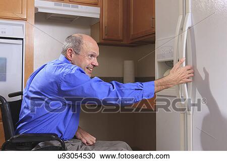 Stock Image - Man with deformed hands in the kitchen. Fotosearch
