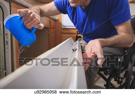 Stock Photo - Man with deformed hands in the kitchen. Fotosearch